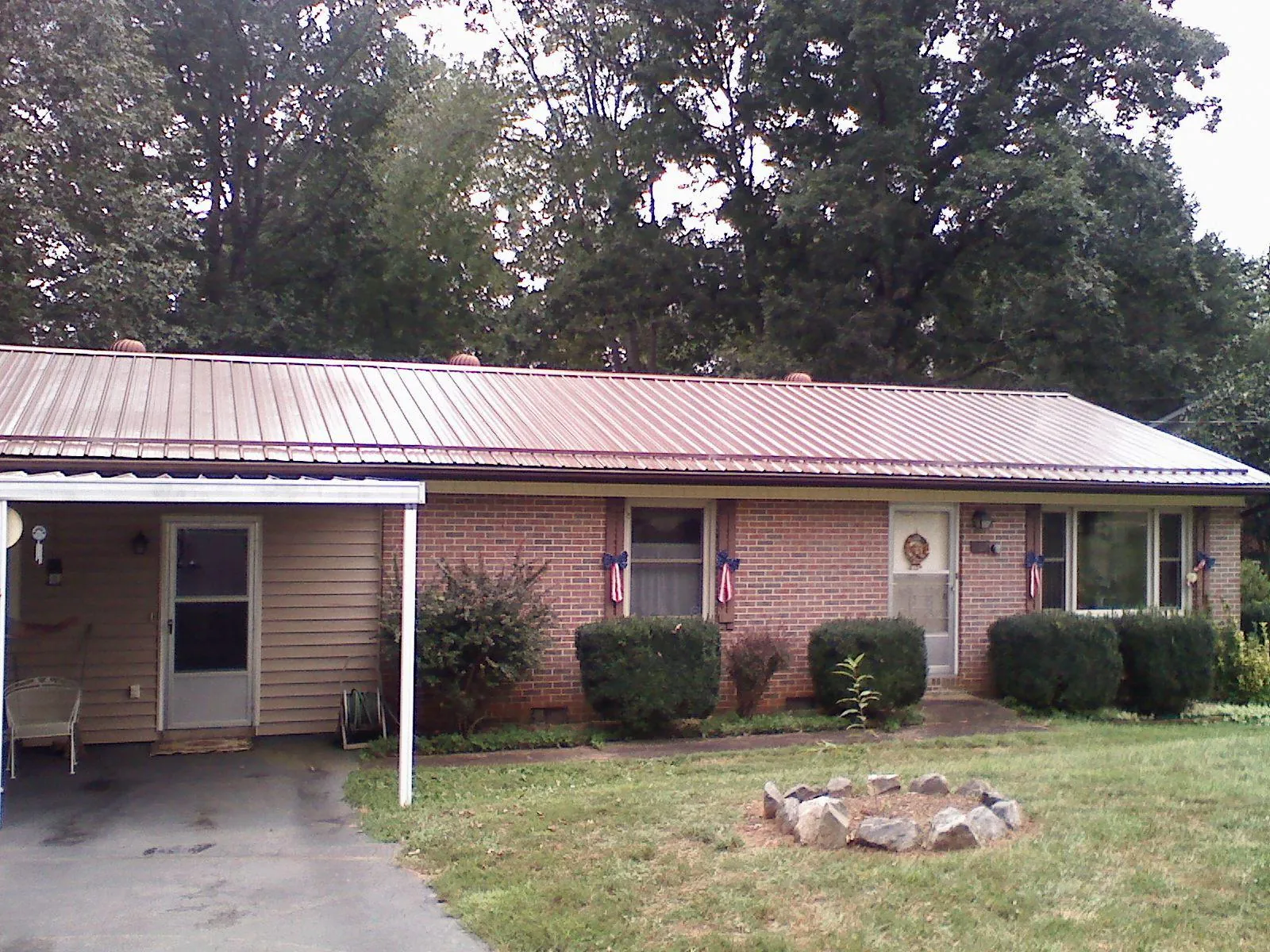 Bronze metal roof and carport on a brick ranch home — Roof Repair work by our crew in Bend